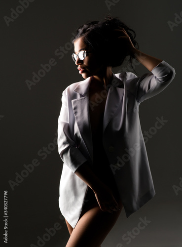 stylish sexy brunette with glasses and white jacket
