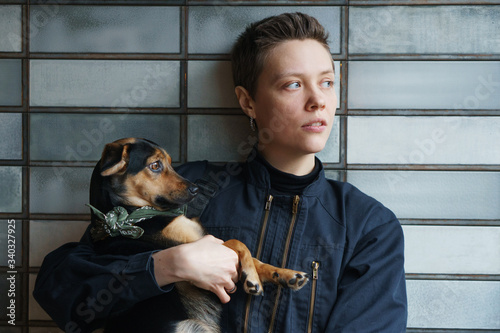 pretty young woman holding dog looking to the outsight photo