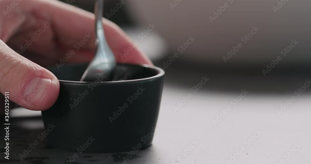 Slow motion man hands mix oil dressing in small blakc bowl