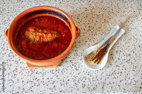 classic Italian Bolognese sauce  rag    with stewed meat in a terracotta cauldron cooked in a wood-burning fireplace