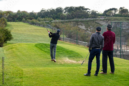 golfistas jugando al golf en un campo de golf ó grupo de amigos jugando al golf © marcantabrico