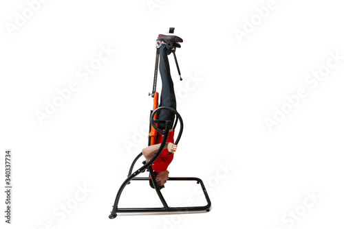 Foto Man doing exercise on inversion table for his back pain, isolated on white