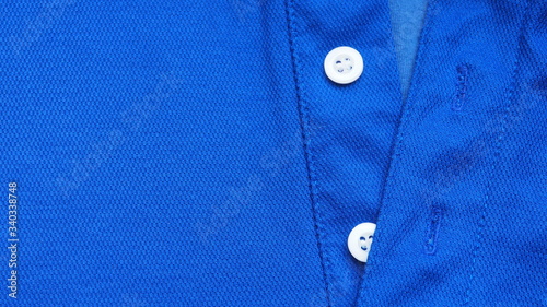 Closeup of new and good quality of bright dark blue shirt with simple white buttons stitched on the placket for modern apparel and beautiful fashion and design concept