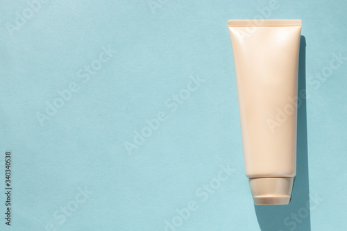 Pattern of tube of cream with empty place for text on a blue background