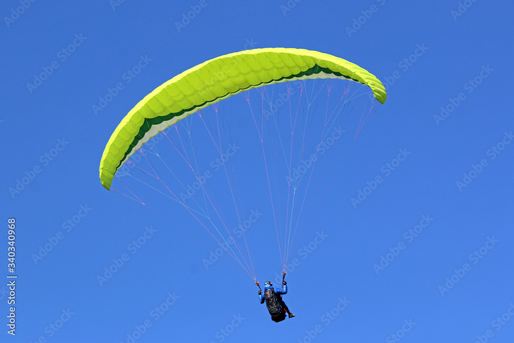 Paraglider flying wing in a blue sky Paraglider flying wing in a blue sky