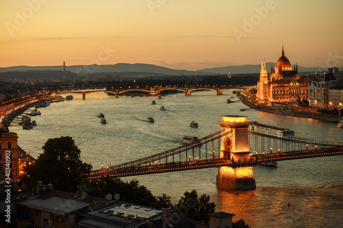 night view of the city of Budapest on the Danube river on which ships with illuminated bridge and parliament sail