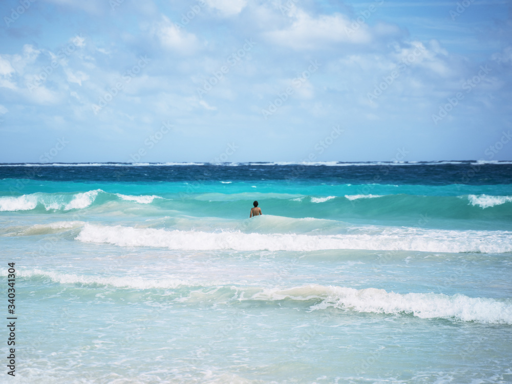 Boy in blue caribbean waves