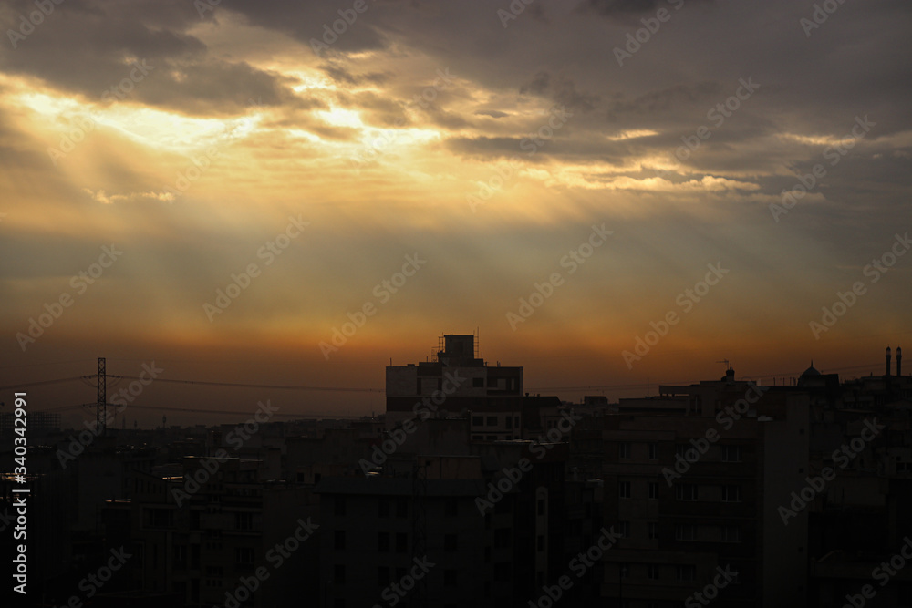 A beautiful landscape of a light beam in the cloudy sky with a background view of a city