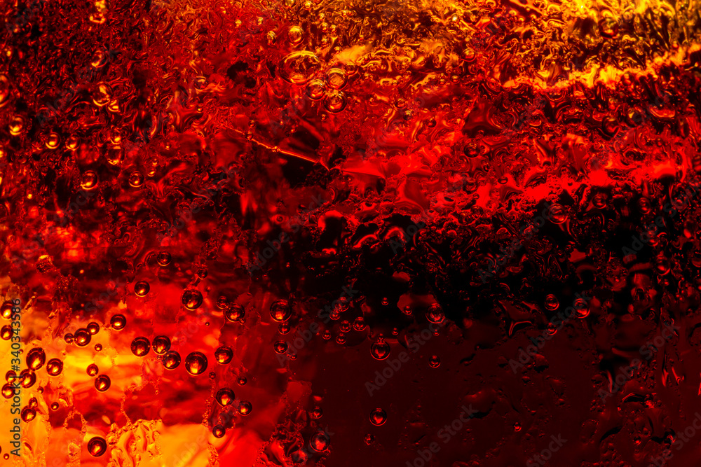 Close up view of the ice cubes in dark cola background. Texture of cooling sweet summer's drink with foam and macro bubbles on the glass wall. Fizzing or floating up to top of surface Close up view of the ice cubes in dark cola background. Texture of cooling sweet summer's drink with foam and macro bubbles on the glass wall. Fizzing or floating up to top of surface