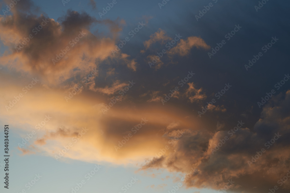 Beautiful evening blue sky at sunset with flaming bright light clouds. A warm summer evening. Beautiful evening blue sky at sunset with flaming bright light clouds. A warm summer evening.