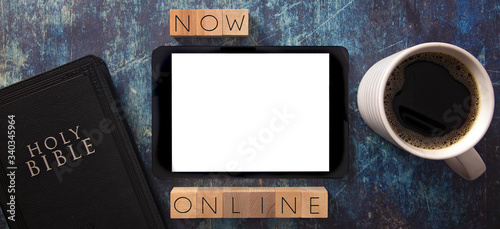 Now Online in Block Letters on a Wooden Table with Bible and Tablet