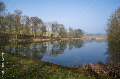 View of a lake in the English countryside on an autumn morning with reflected trees