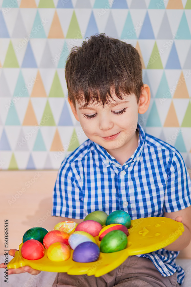 Fototapeta premium Different color Easter Eggs in a child's hands- egg hunt.