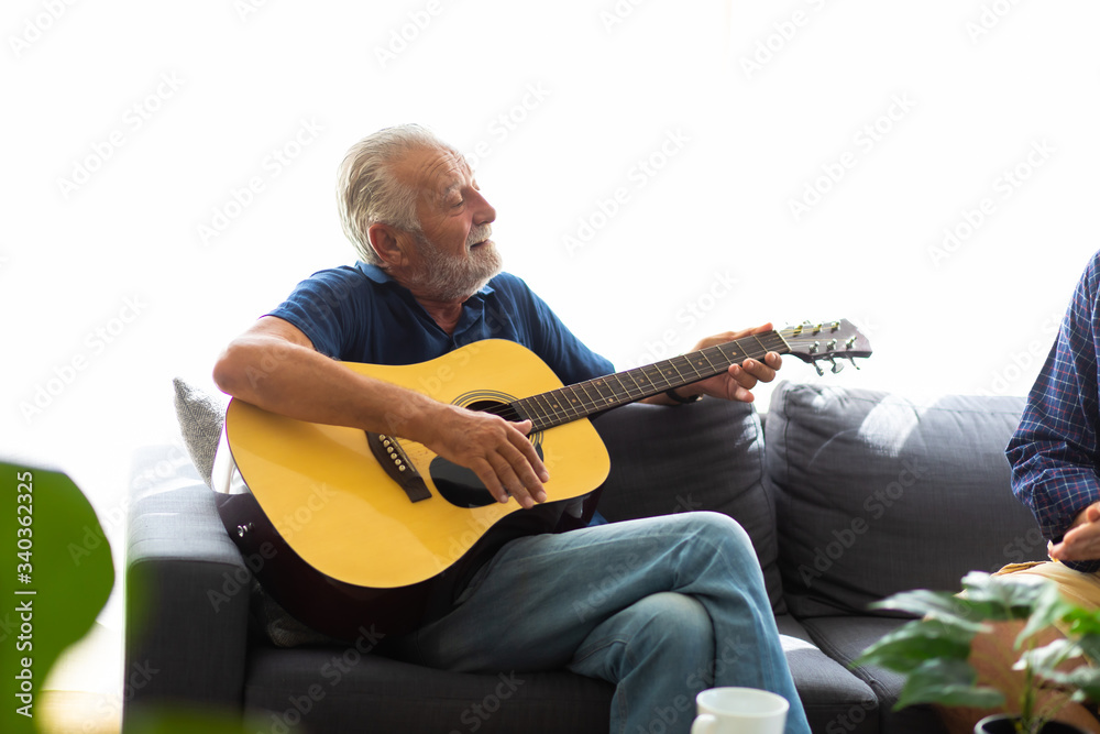 family time together at home concept. lifestyle. Portrait of happy and handsome bearded senior man in glasses enjoy music in living room indoors at home. Elderly man