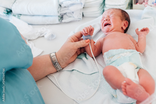 Doctor checks newborn's health status in hospital