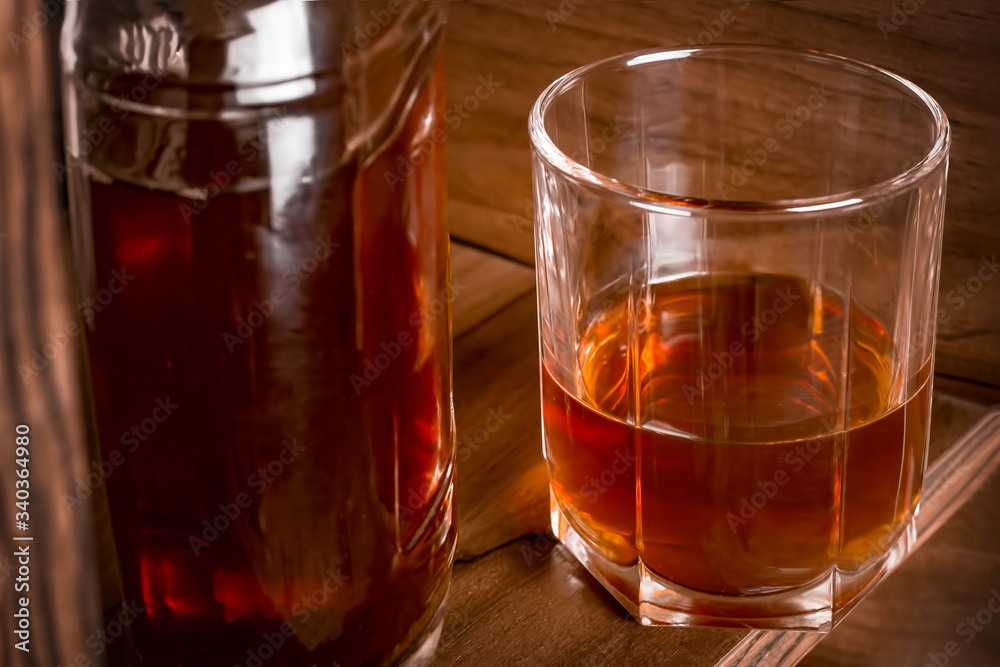 Glass cup and bottle with alcohol on the bar shelf. Glass cup and bottle with alcohol on the bar shelf.