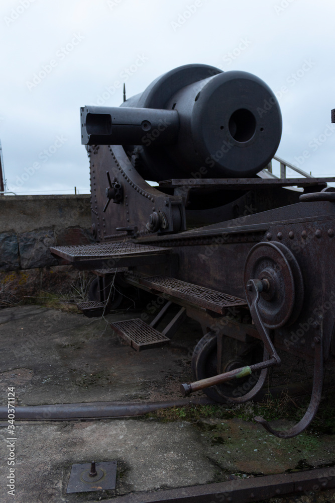 The case and the turning mechanism of a large old cannon from the time of the Russian Empire in the historical fort Suomenlinna, in Helsinki, Finland, autumn day The case and the turning mechanism of a large old cannon from the time of the Russian Empire in the historical fort Suomenlinna, in Helsinki, Finland, autumn day