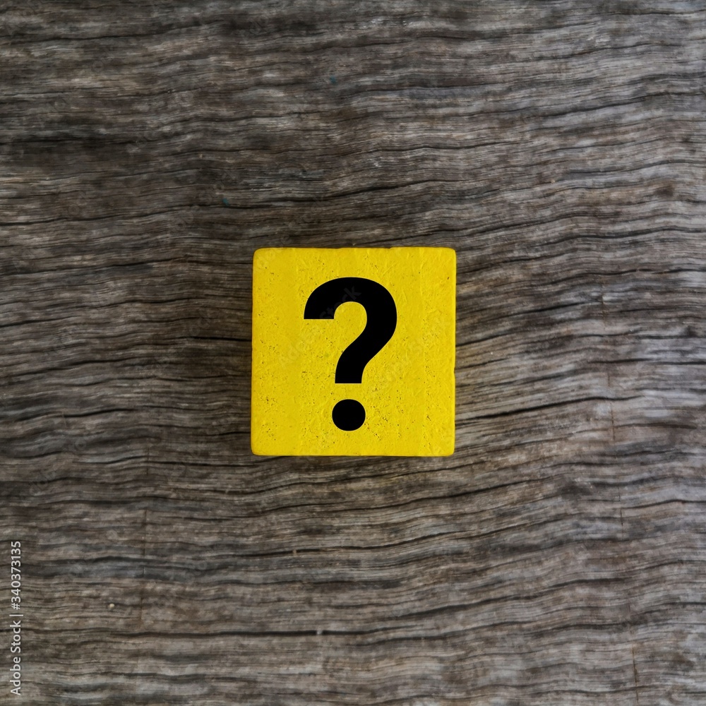 Question mark on yellow wooden cube over wooden background Question mark on yellow wooden cube over wooden background
