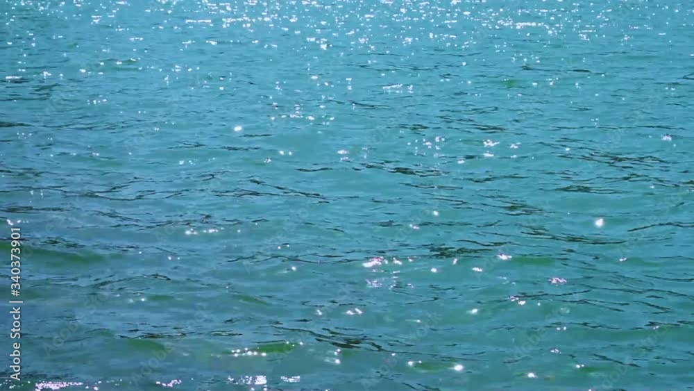 Blue beautiful sea waves sparkle in the sun. Motion of water. Summer. Bright shiny background. Natural pattern. Relax, vacation. Reflection. Colorful tropical landscape. Blue beautiful sea waves sparkle in the sun. Motion of water. Summer. Bright shiny background. Natural pattern. Relax, vacation. Reflection. Colorful tropical landscape.
