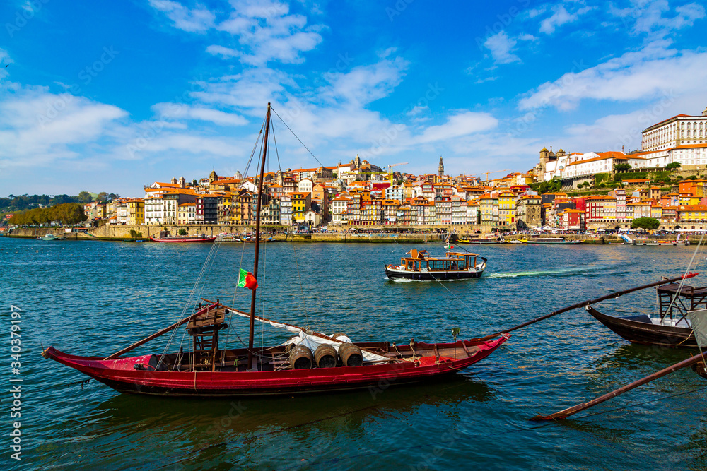 Porto, Portugal, colorful houses of Riberia district and the Douro River with traditional Rabelo boats with wine barrels