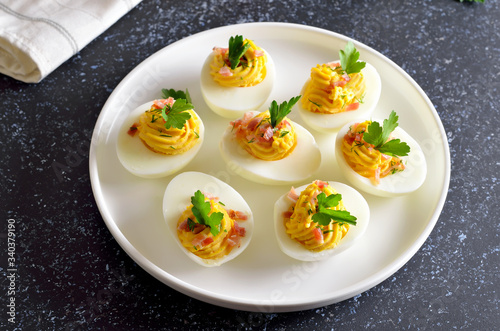 Stuffed eggs with egg yolk, bacon, mustard and parsley