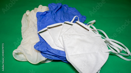 Set of FFP2 medical masks and disposable blue and white medical gloves. Face mask protection against pollution, virus, flu and coronavirus. Health care and surgical concept. Green background