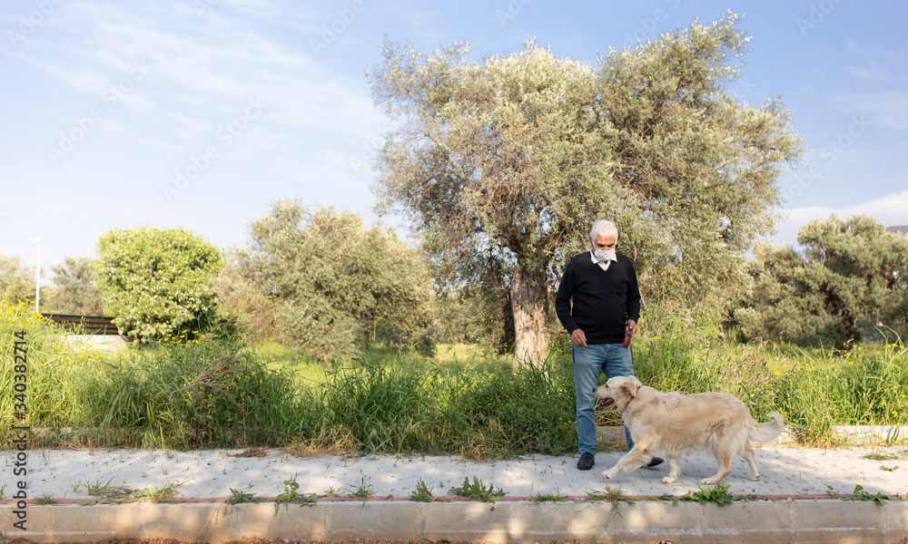 Obraz premium senior man in mask with his pet dog on street because of air pollution and epidemic in city. Protection against virus, infection