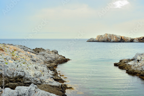 paisaje de rocas de mar con algas y cielo con nubes en la costa mediterránea de España