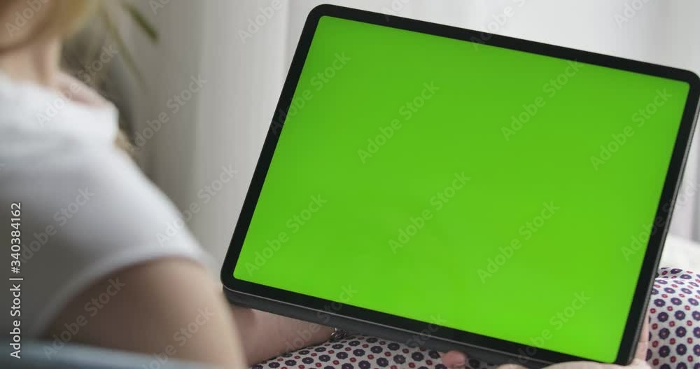 Unrecognizable Caucasian woman holding tablet with green screen. Close-up of chromakey on device. Modern technologies, lifestyle. Shooting over shoulder. Cinema 4k ProRes HQ.