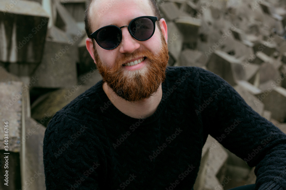 young man with beard and glasses on beach near sea young man with beard and glasses on beach near sea