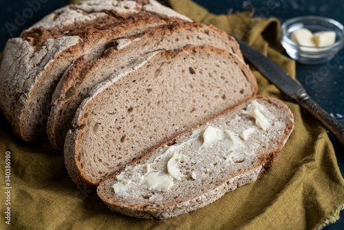 Homemade reshly baked country bread made from wheat and whole grain flour sliced with butter