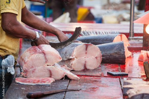 Vászonkép Hands with knife chopping fish outdoors