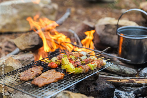 BBQ / Steak Meat Roast on a natural fire Camping atmosphere. Relaxing time camping on a mountain. Activity in holiday concept.