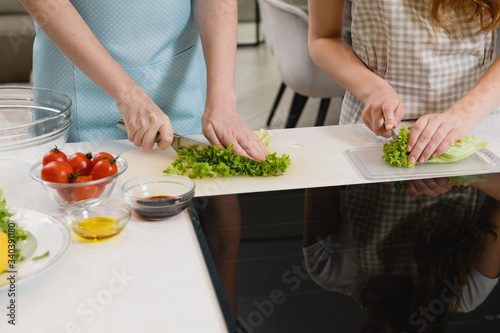 Hands cut greens for salad at home