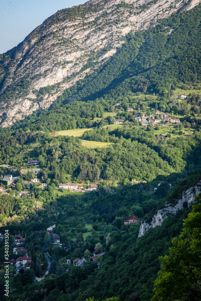 Small houses nestled on a lush green hillside in the french alps in Grenoble France