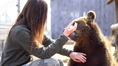 Detail close up - The Zoo keeper gives a suckling thumb to a young cute bear who thinks it's his mother - detail close up - 4k