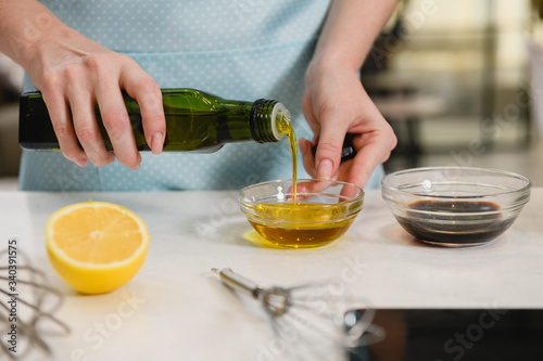 Woman hand pour vegetable oil in bowl
