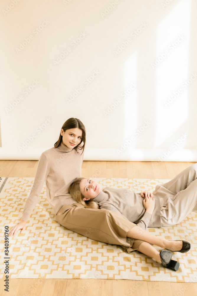 Close up fashionable portrait couple of two cute girls best friends smiling and embracing on white background. Perfect hairstyle. Nude make up. Close up fashionable portrait couple of two cute girls best friends smiling and embracing on white background. Perfect hairstyle. Nude make up.
