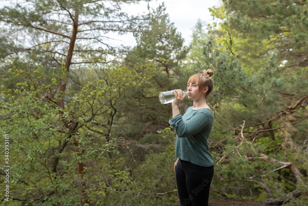Woman drinking water with glass bottle Woman drinking water with glass bottle