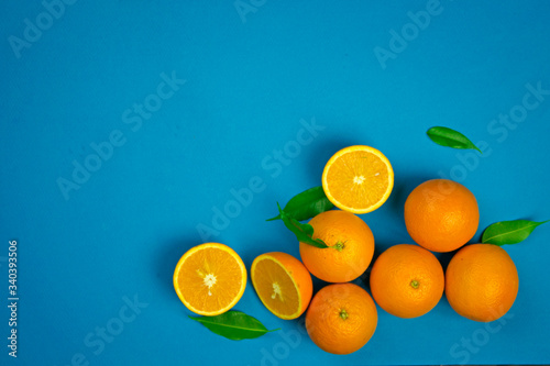 orange vibrant oranges laid out on a blue background with place for text top view, citrus vitamin fruits, organic healthy food © Victoriia