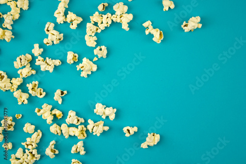 popcorn sprinkled on a blue background, place for text, concept of relaxing and spending free time, watching movies