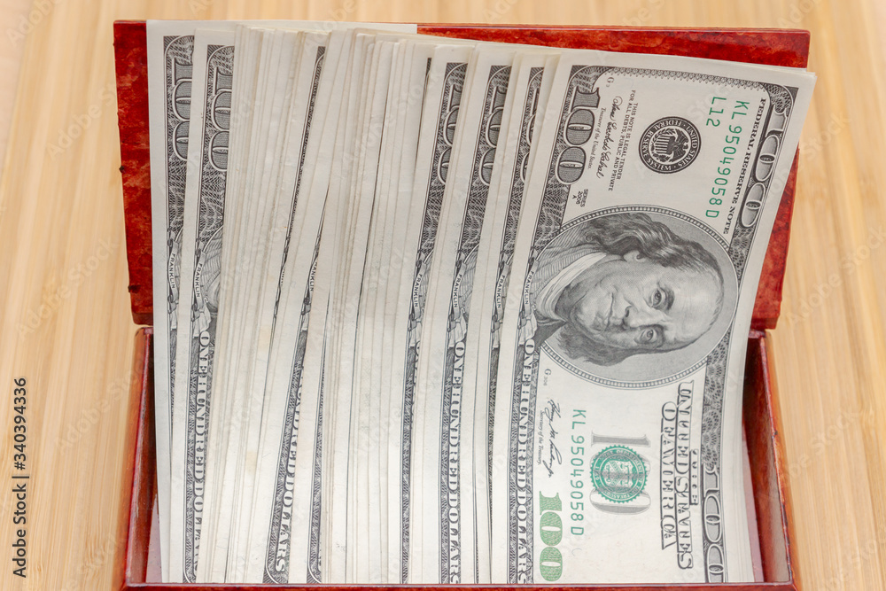 American hundred dollar bills in large quantities in a wooden box American hundred dollar bills in large quantities in a wooden box