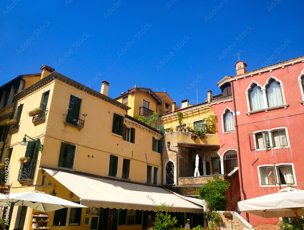 Colored houses with canopies against the blue sky in Venice. Italy