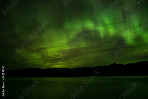 Aurora borealis over water and mountains