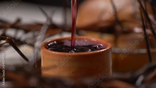 Cup being filled with wine with Crown of Thorns Surrounding the cup