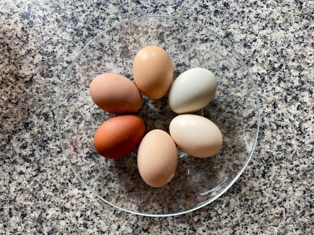 A bowl of beautiful eggs in natural assorted shades. A bowl of beautiful eggs in natural assorted shades.