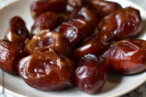 Washed ripe date fruits on a white plate