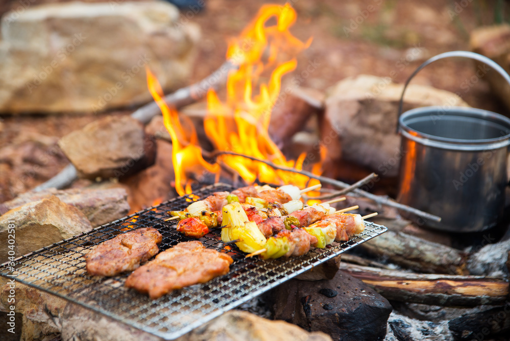 BBQ / Steak Meat Roast on a natural fire Camping atmosphere. Relaxing time camping on a mountain. Activity in holiday concept.