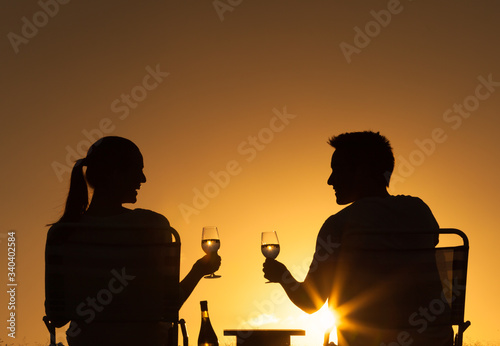 Couple enjoying a romantic picnic at sunset. 