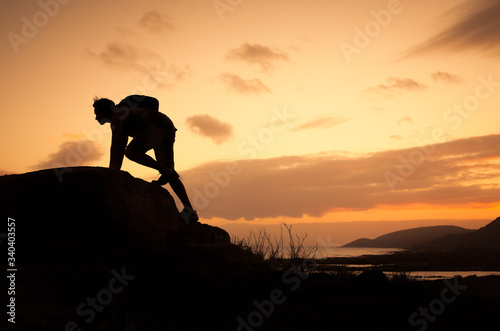 Man climbing up to the top of a mountain. 
